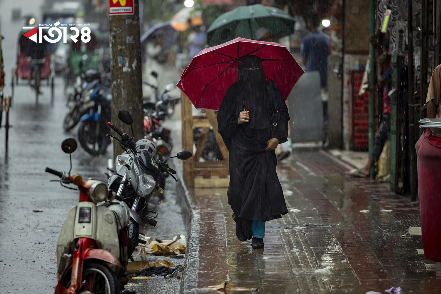 ছাতা হাতে কর্মস্থলে যাচ্ছেন এক নারী। ছবি: নূর এ আলম