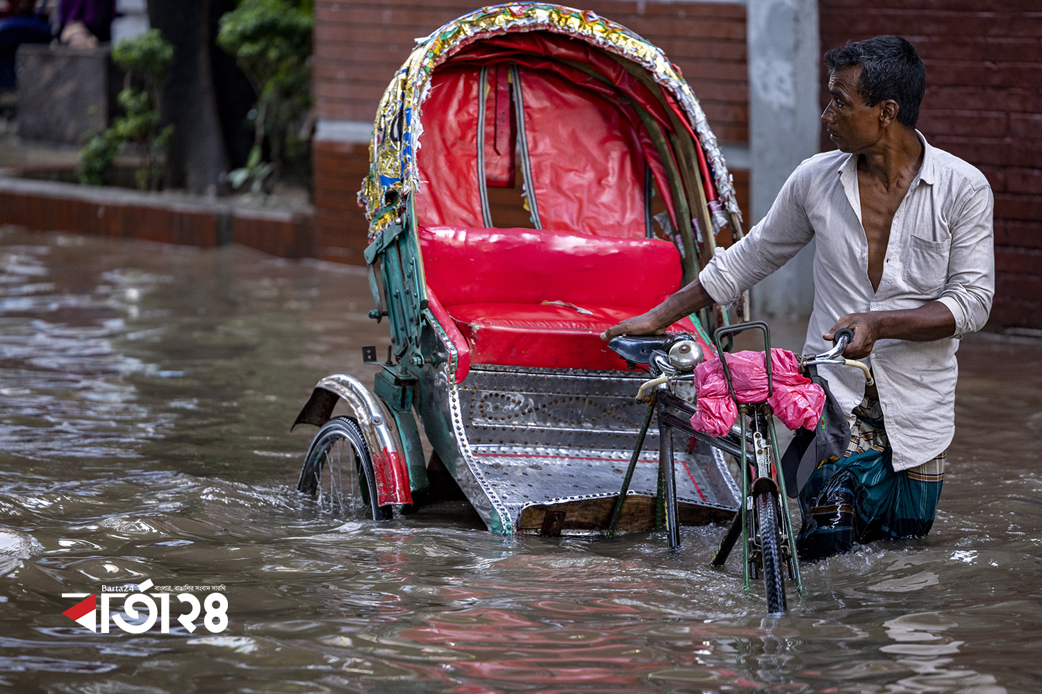 পানির মধ্যে খালি রিকশা টেনে নিচ্ছেন এক রিকশা চালক/ ছবি: নূর-এ-আলম