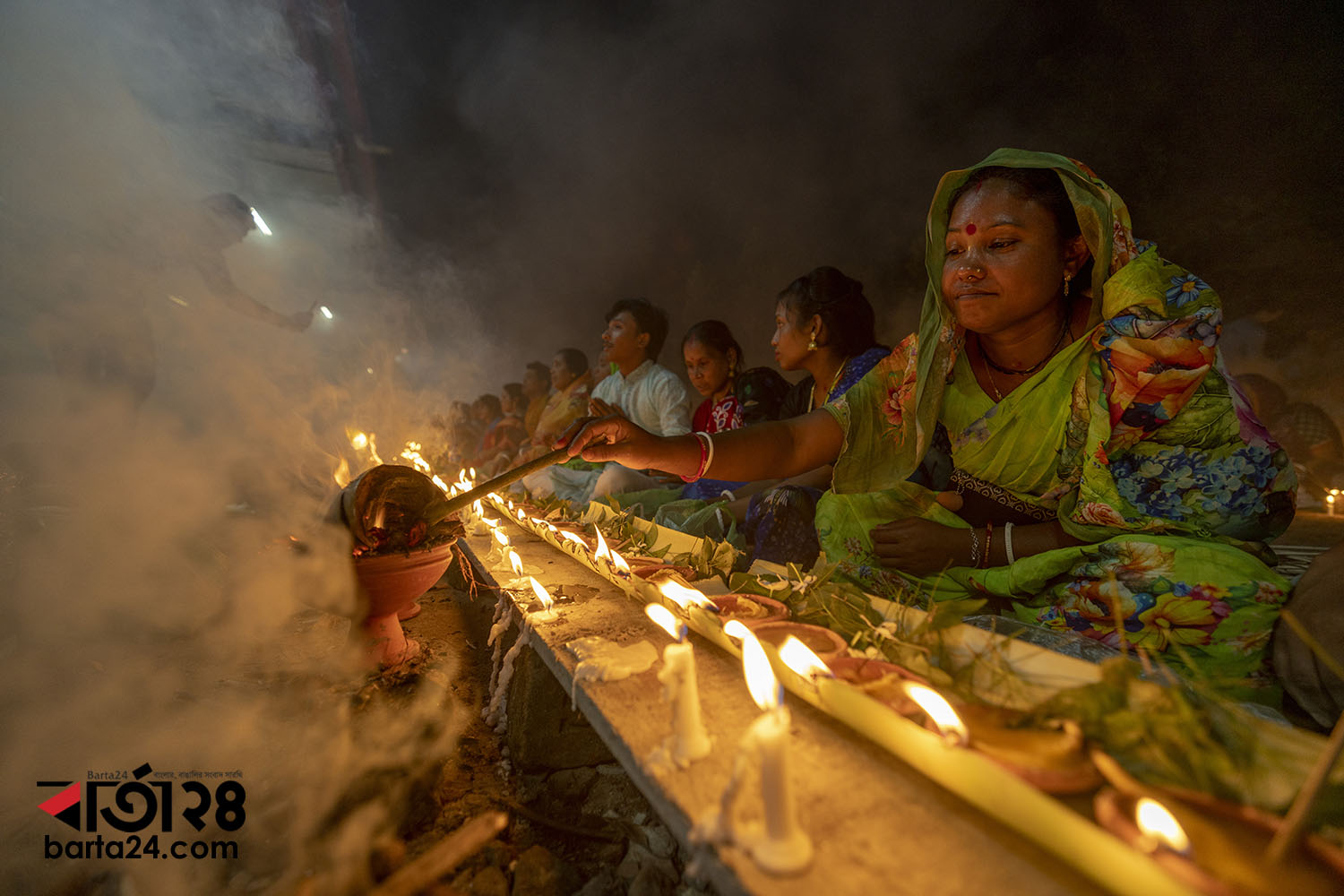 ঢাকার স্বামীবাগ লোকনাথ আশ্রমে প্রদীপ জ্বালাচ্ছেন এক পূর্ণার্থী/ছবি: নূর-এ-আলম