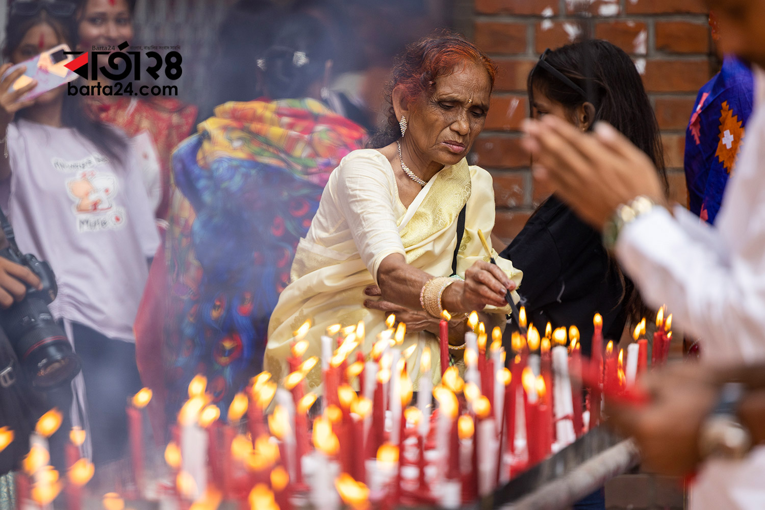 এবারের মতো দুর্গাপূজায় মোমবাতিতে আলো জ্বালাচ্ছেন এক ভক্ত। ছবি: বার্তা২৪.কম/নূর-এ-আলম